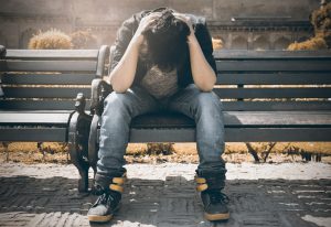 man-in-black-shirt-and-gray-denim-pants-sitting-on-gray-1134204-300x206.jpg