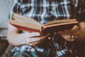 person-reading-book-while-sitting-1472841-300x200.jpg
